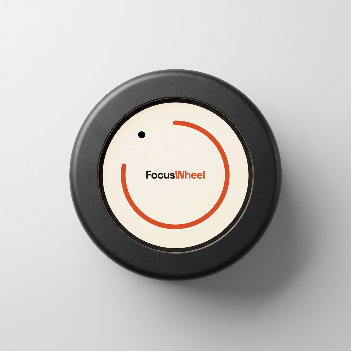 The FW-1 seen from directly above: a matte black wheel with a rounded bezel and a recessed cream display carrying the FocusWheel wordmark inside an orange ring.